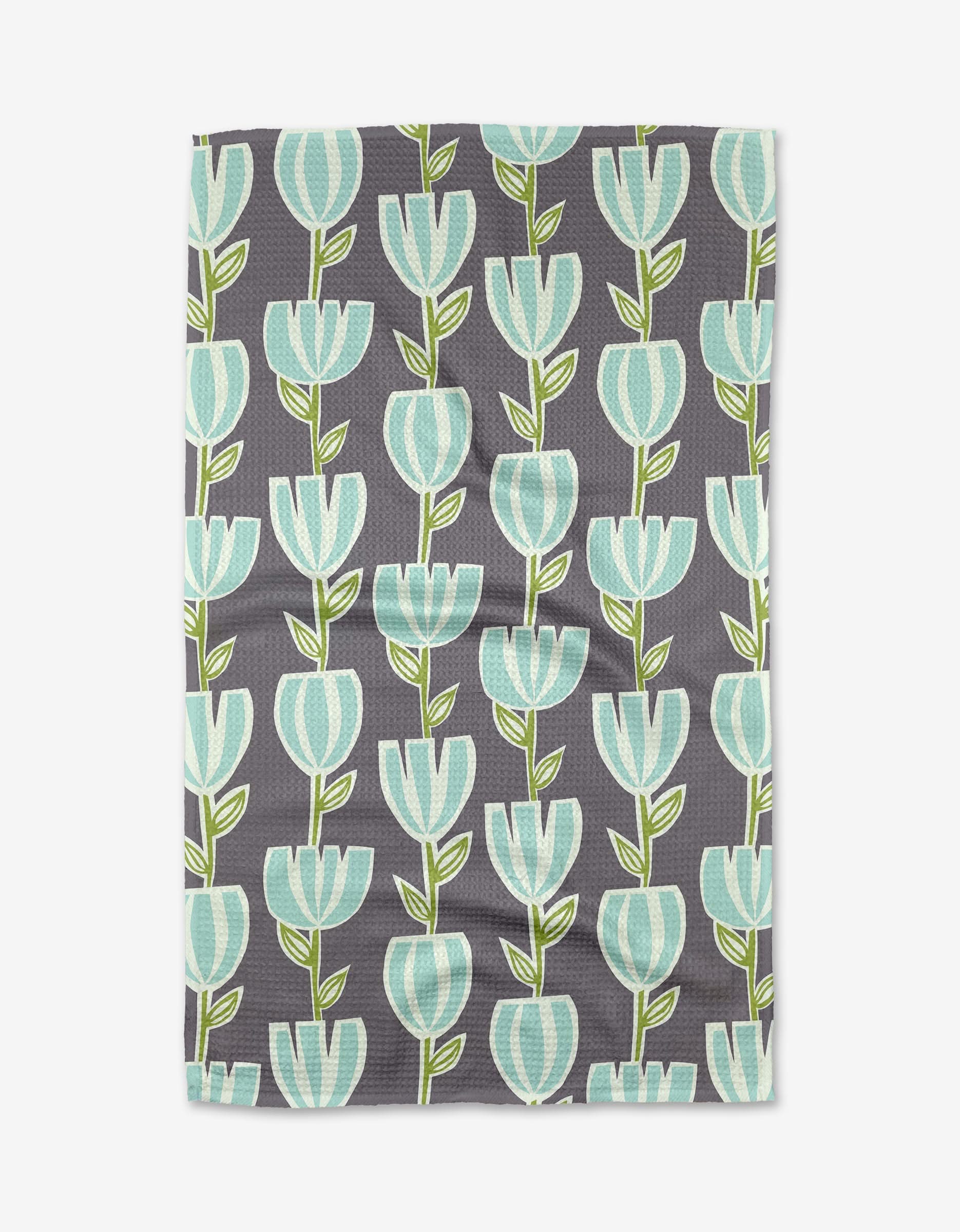 The Tulips for Days Geoweave tea towel by Lizzie Clark features a gray background with rows of stylized turquoise and white tulips and green stems.
