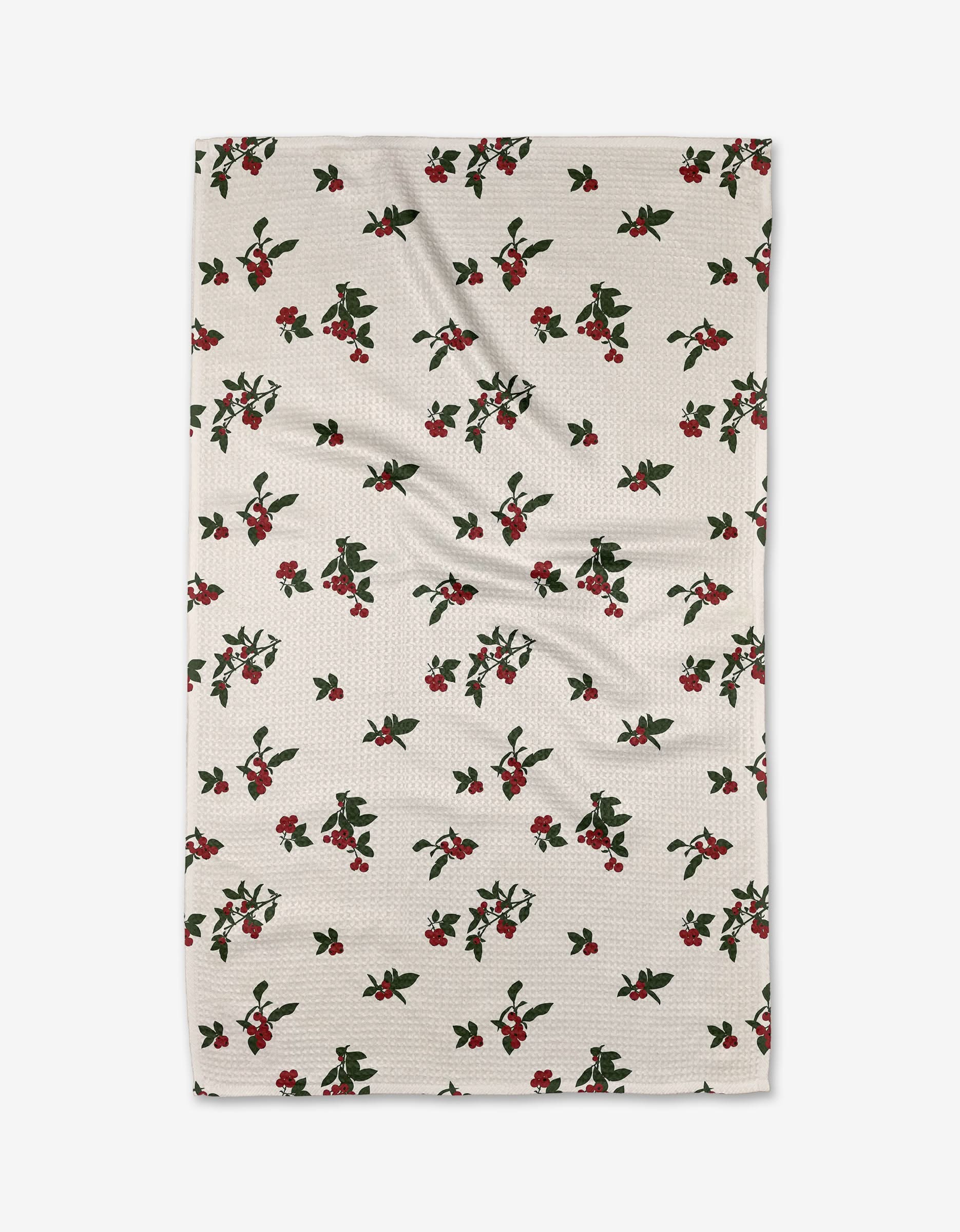 The Aubrey Fairchild Vintage Holly Berry kitchen towel is white and textured, featuring a repeating pattern of small red holly berries with green leaves scattered across the surface.