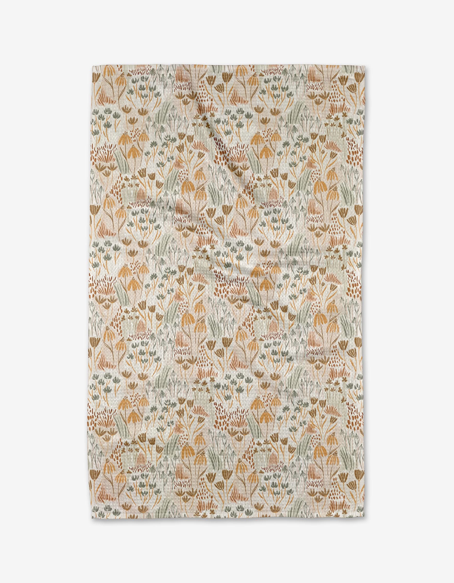 The Hufton Studio Woodland Floral tea towel features a rectangular Geoweave fabric with stylized flowers and leaves in muted yellow, orange, green, and blue on a cream background. It is shown laid flat with slight wrinkles.