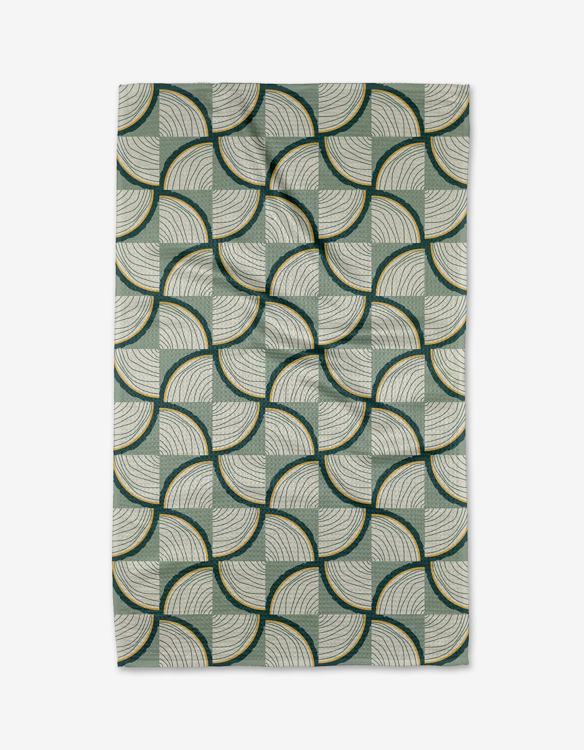 The Twig + Spark Woodpile rug features fan-shaped geometric arcs in green, cream, and dark yellow on a light background—perfect for pairing with an eco-friendly tea towel in your kitchen décor.