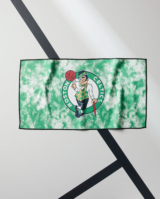 A green and white tie-dye towel featuring the Boston Celtics logo with the leprechaun mascot, laid flat on a light background with black diagonal lines.