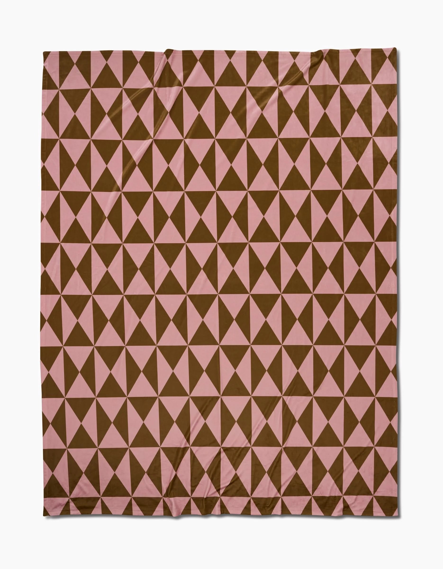 The Geometry Bronze blanket is a square, eco-friendly throw made from recycled materials. It features a repeating geometric pattern of brown and pink triangles in a grid for a diamond-like effect and has a slightly wrinkled appearance.