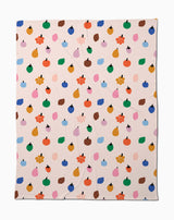 The Fruit Basket Butter Blanket by Jennifer Bouron is a beige, eco-friendly throw made from recycled materials, featuring a playful mix of fruit shapes, blobs, and flowers in vibrant colors.