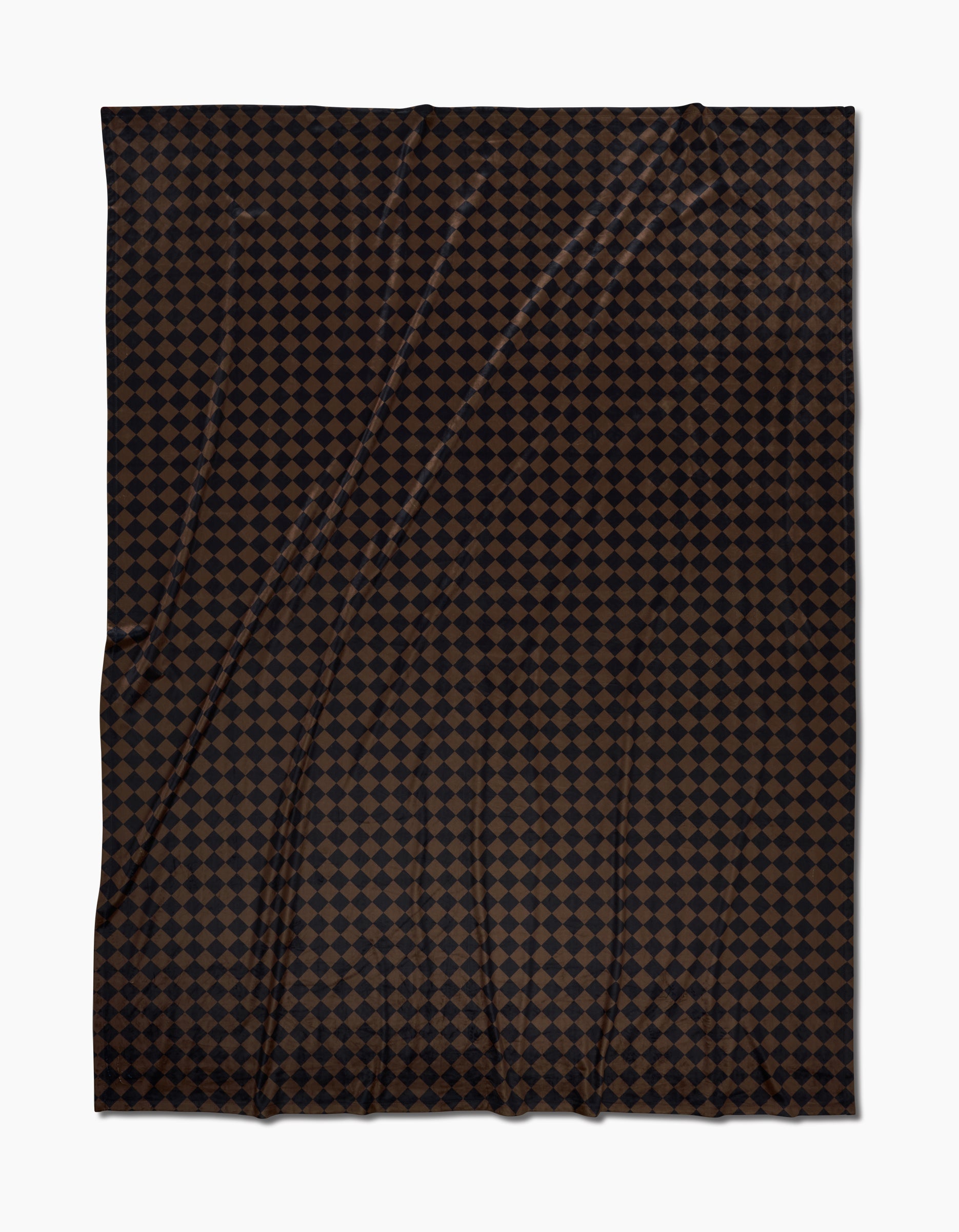 The Geometry Gridlock Butter Blanket showcases a repeating pattern of small, dark brown diamonds on black, laid flat with gentle folds—crafted from recycled materials for an eco-friendly touch.