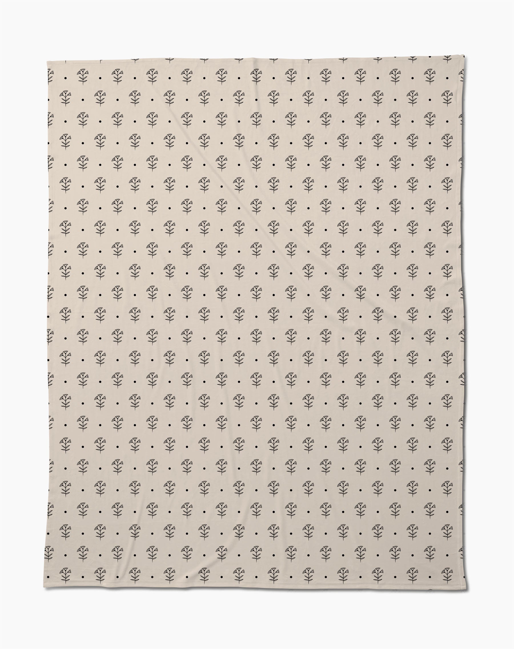 The Inked Bloom by Cole Strem is an eco-friendly, beige blanket with a simple, repeating black floral motif. Made from recycled materials, it appears soft with subtle natural wrinkles.