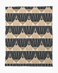 The Letitia Dark Butter Blanket by Amy MacCready features black and tan geometric fan patterns on white, arranged in horizontal rows. Made from eco-friendly recycled materials, it offers a modern, minimalist style.
