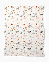 The Coit Creative Light Farm Animals blanket showcases a charming pattern of farm animals, trees, flowers, and barns on a white background. Made from eco-friendly recycled materials, its a cozy and conscious addition to your home.