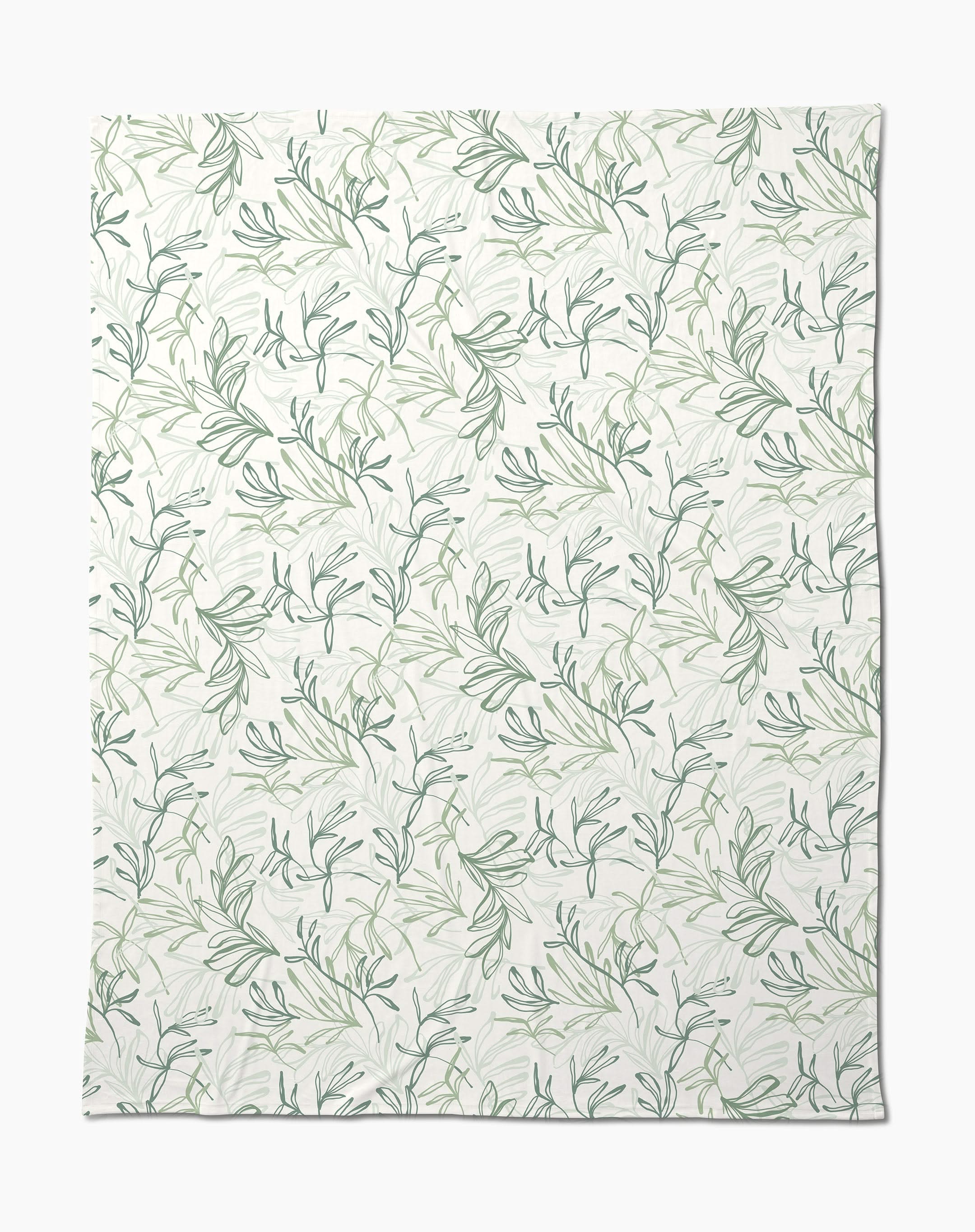 The Organic Foliage Butter Blanket by Kris Ruff is white, silky soft, and features a subtle repeating pattern of green leafy branches and vines for a delicate botanical look.