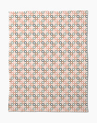 The Russet Crossroads Butter Blanket by Charlie Rowan Designs features a symmetrical geometric pattern of black squares and orange lines on white, crafted from recycled materials for an eco-friendly, stylish look.