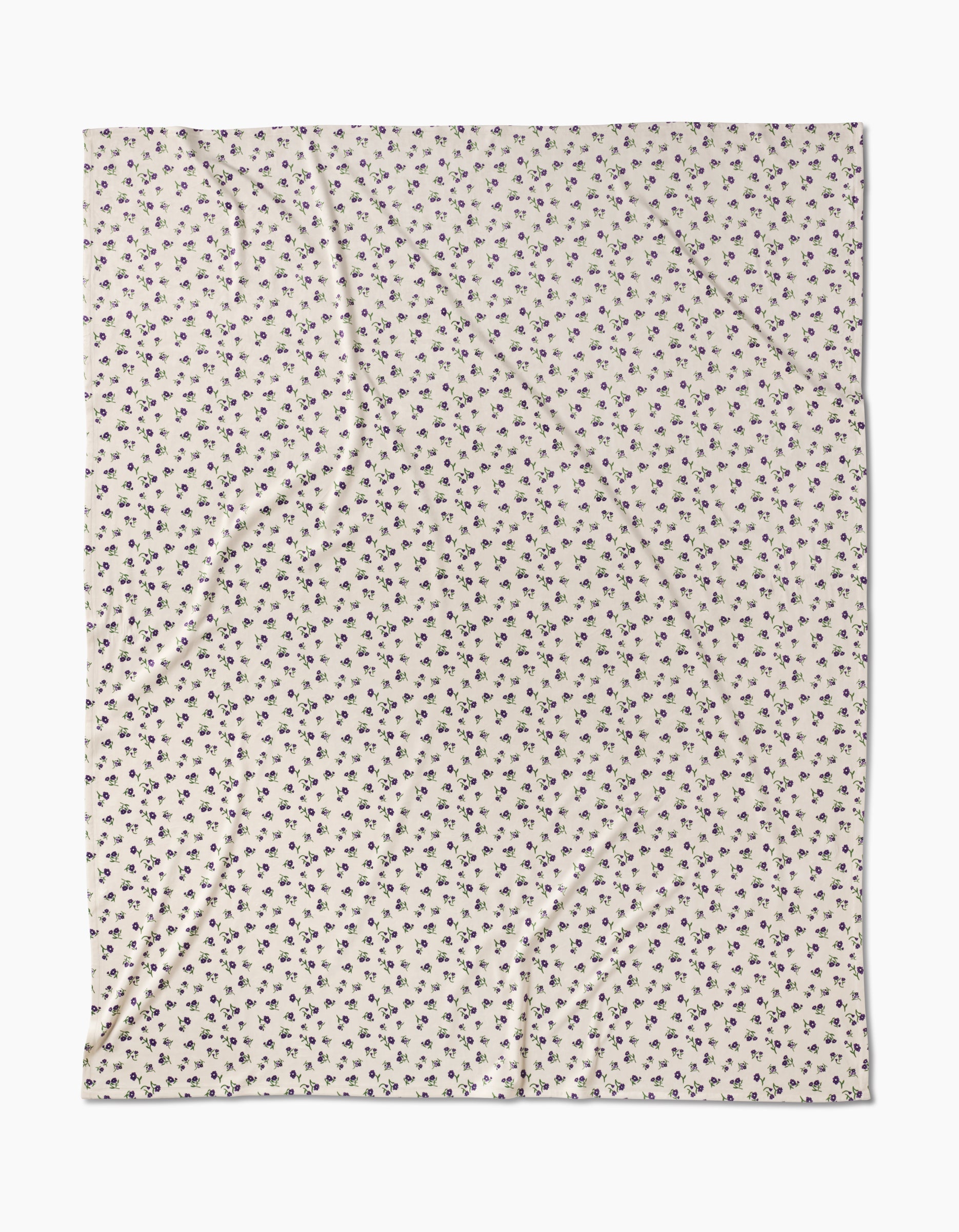 The Violet Sound fabric by Geometry features a cream base with a repeating small black floral pattern, made from recycled materials and displayed flat to reveal subtle wrinkles and folds.