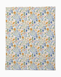Wildflower Vine Blush by Danelys Sidron is a silky soft fabric with a vibrant floral pattern of small orange, blue, pink, and yellow flowers and green leaves densely scattered on a white background.