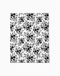 The Danelys Sidron Botanical Silhouettes Charcoal blanket or sheet is white with a repeating black floral and leaf pattern, offering silky softness for a timeless, elegant style.