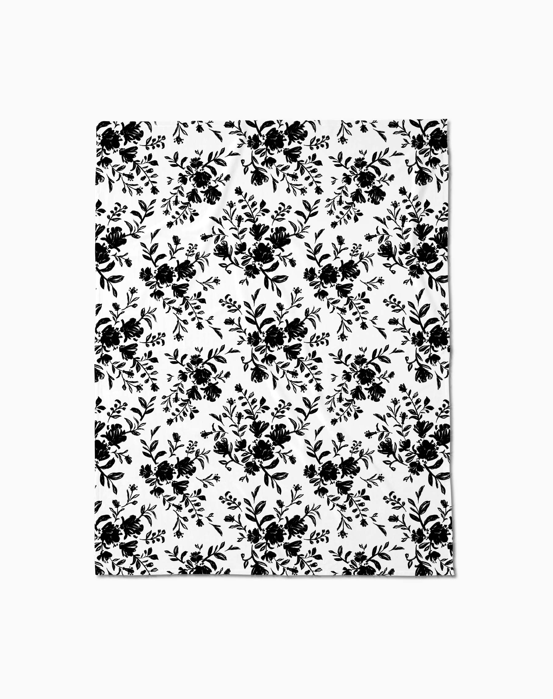 The Danelys Sidron Botanical Silhouettes Charcoal blanket or sheet is white with a repeating black floral and leaf pattern, offering silky softness for a timeless, elegant style.
