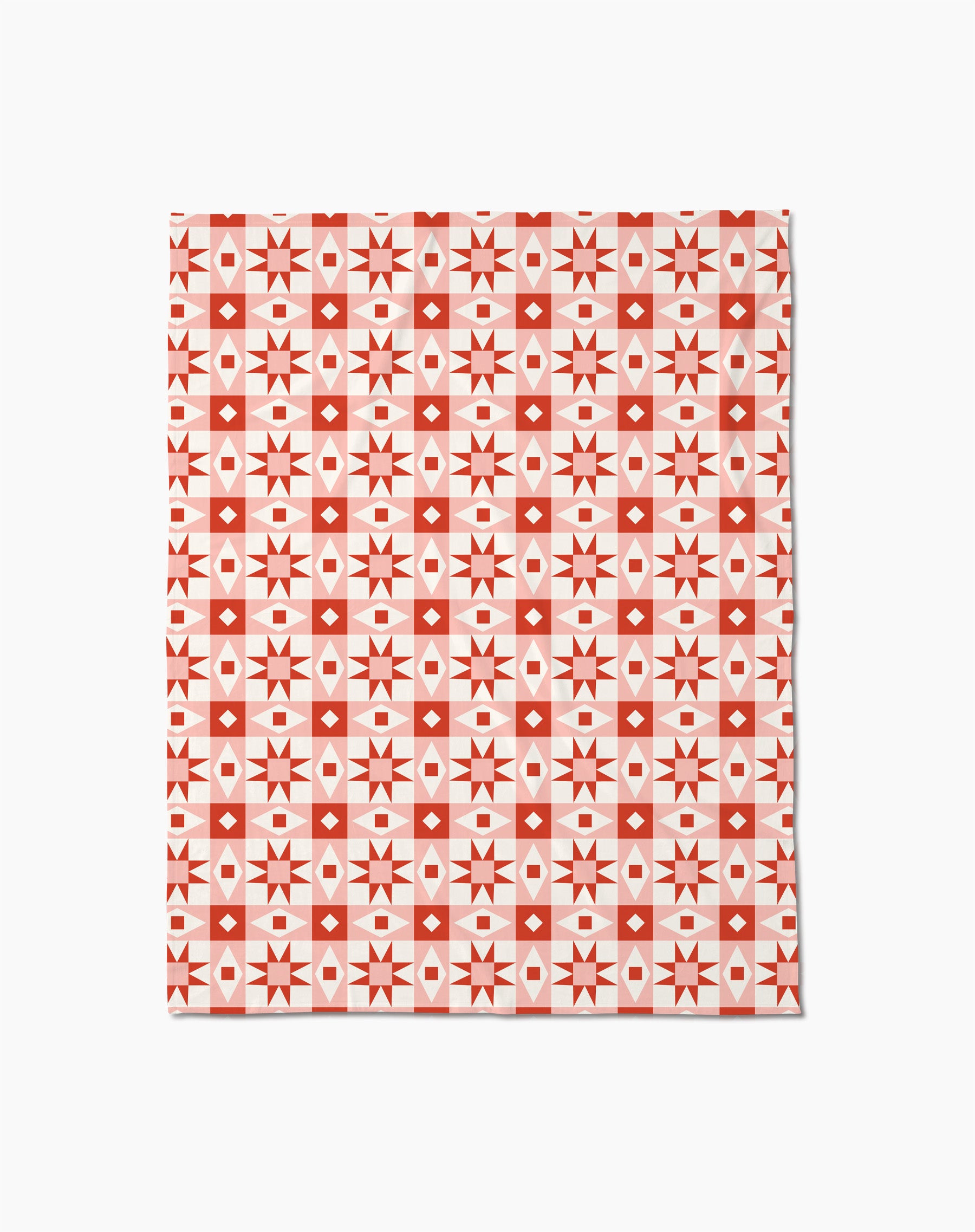 The Chalet Butter Blanket by Charlie Rowan Designs features a geometric pattern of red and white squares, diamonds, and stars in a grid on white—perfect as a soft throw blanket.