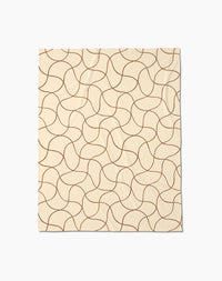 The Geometry Clarity throw blanket is beige and rectangular, featuring a soft texture with an abstract pattern of curving brown lines that form a repeating, interconnected design across the surface.