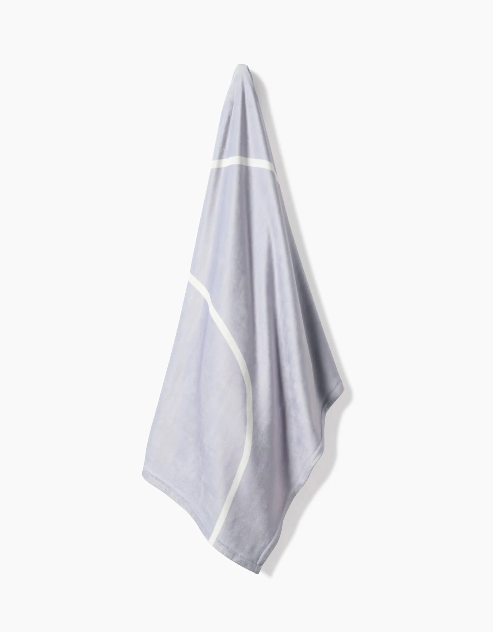 The Geometry Crossover towel, made from recycled materials, features a light gray base with white geometric lines and is displayed against a plain white background.