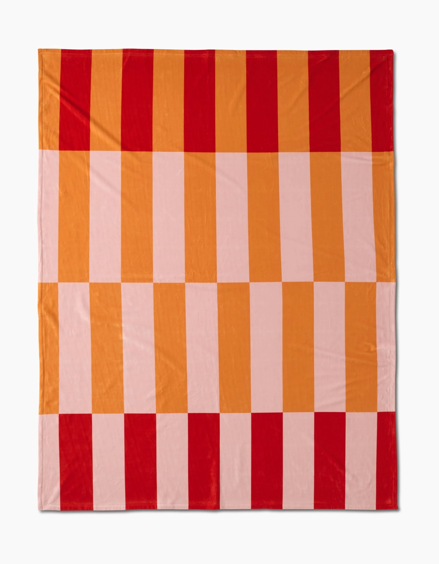 The Geometric Sunset Butter Blanket by Geometry showcases bold red, orange, and light pink checkered stripes. Made from recycled materials, it offers a modern geometric design with silky softness.