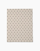 Inked Bloom by Cole Strem is a beige Butter Blanket with a repeating pattern of small, simple black tree illustrations, crafted from eco-friendly recycled materials.