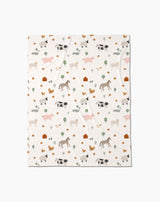 The Light Farm Animals Butter Blanket by Coit Creative is made from eco-friendly recycled materials and features soft pastel cows, pigs, horses, chickens, trees, and barns in a charming repeating pattern.