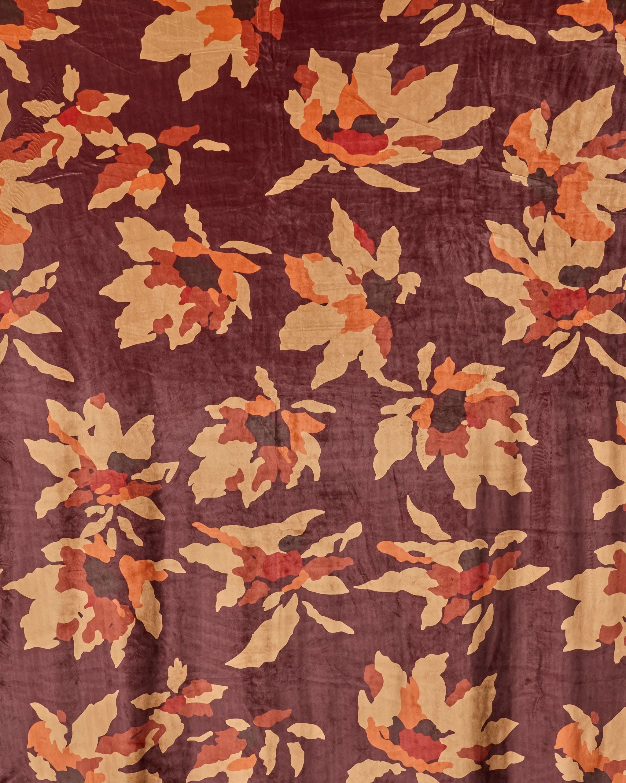 Mulberry Bloom by Geometry features large abstract florals in tan, orange, and dark red on a maroon background—perfect for a bold, vintage-inspired butter or throw blanket that adds warmth and style to any room.