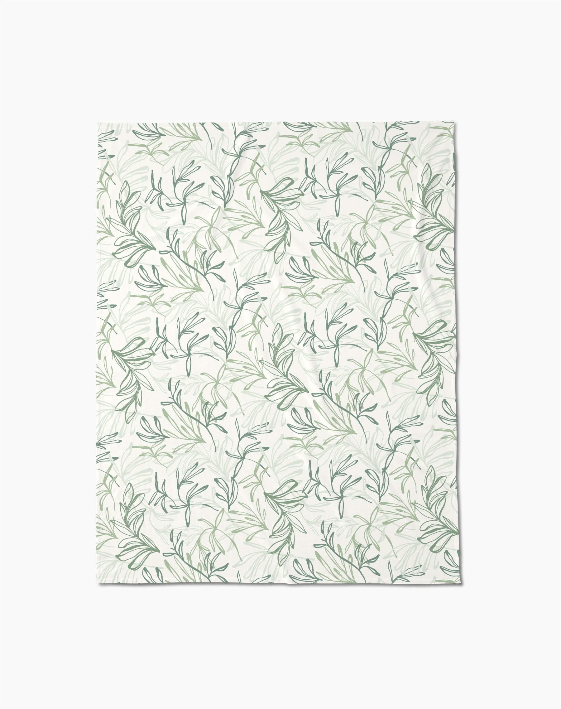 The Organic Foliage Butter Blanket by Kris Ruff features a delicate green and gray leafy branch pattern on white, crafted from recycled materials for silky softness.
