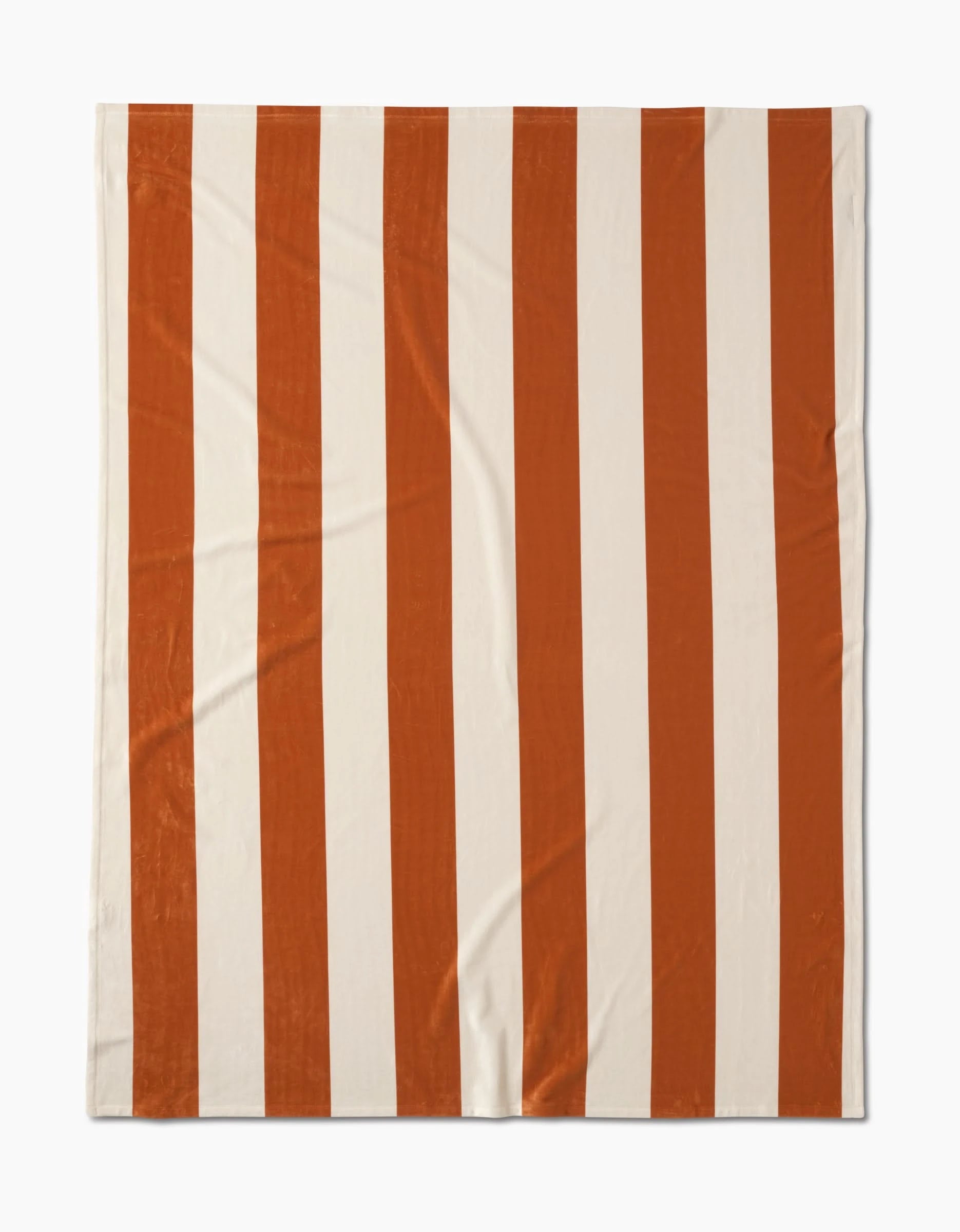 The Radiance Butter Blanket by Geometry features wide vertical stripes in alternating orange and white, crafted from recycled materials and displayed flat on a white background.
