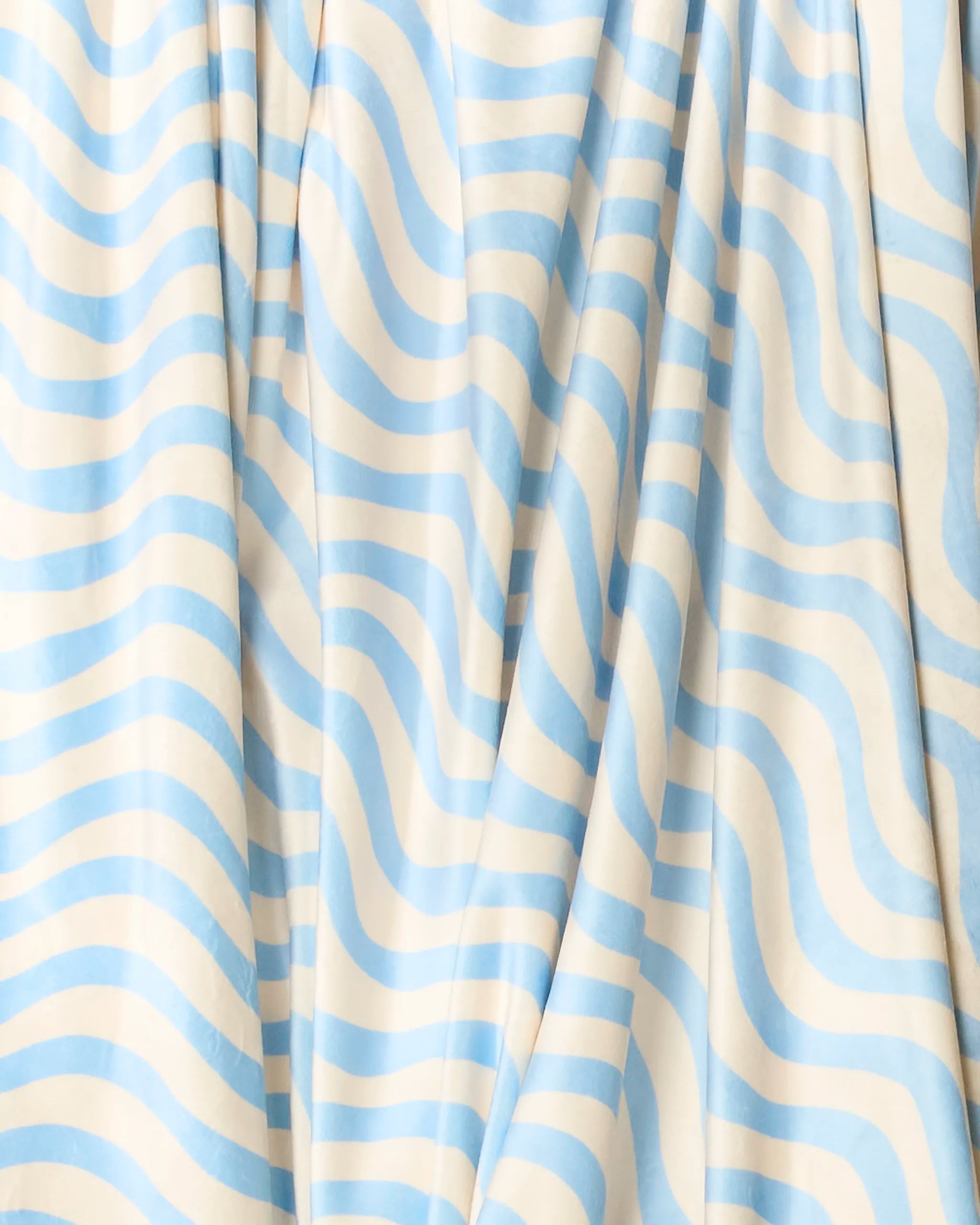 Spatial by Geometry features light blue and white fabric with wavy horizontal stripes, softly draped for gentle folds and shadows—perfect as a cozy, soft throw blanket.