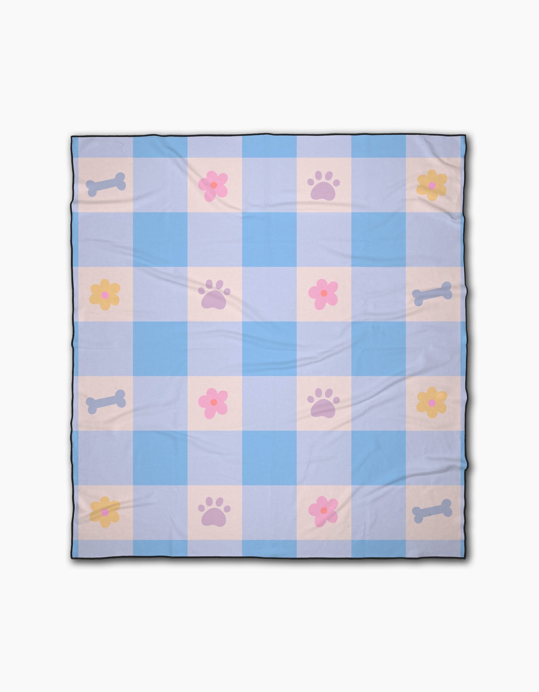 The Blue Sky Picnic Dreams blanket by Letters By Shells is a light blue and white checkered beach blanket with pink paw prints, yellow and pink flowers, and blue bones in a repeating pattern.