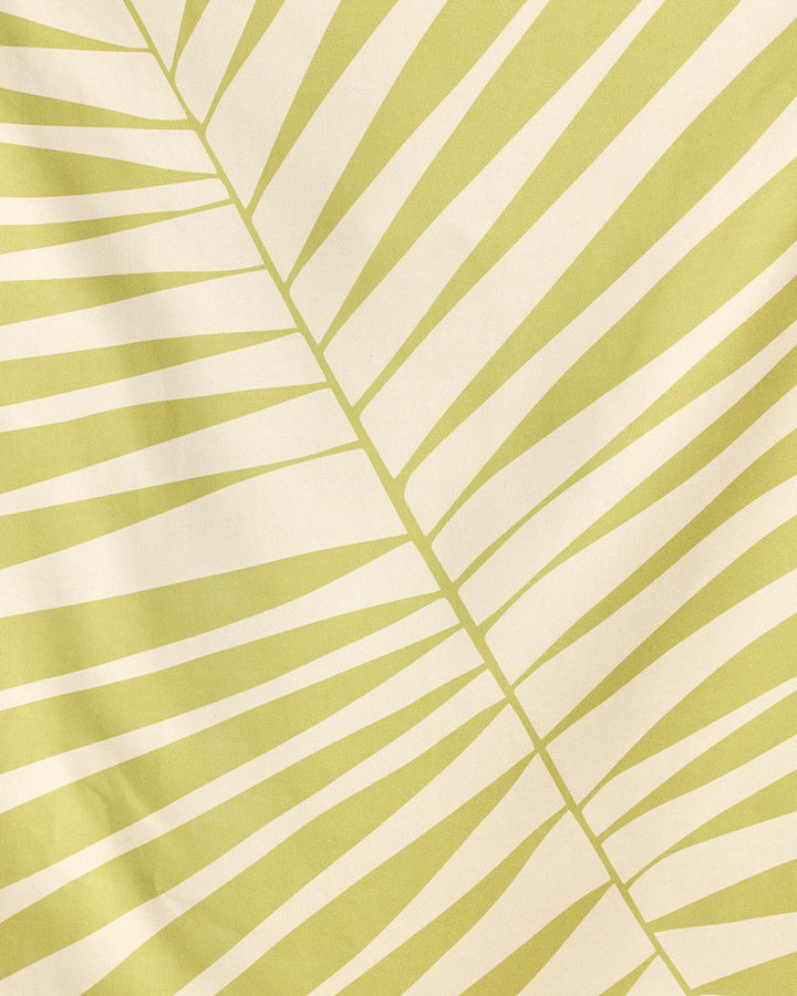 Cabana Club by Geometry features a pale yellow and cream abstract leaf pattern with diagonal lines radiating from a central vein—resembling a palm frond. Its simple, geometric design is perfect for their quick-drying beach blanket made from recycled materials.