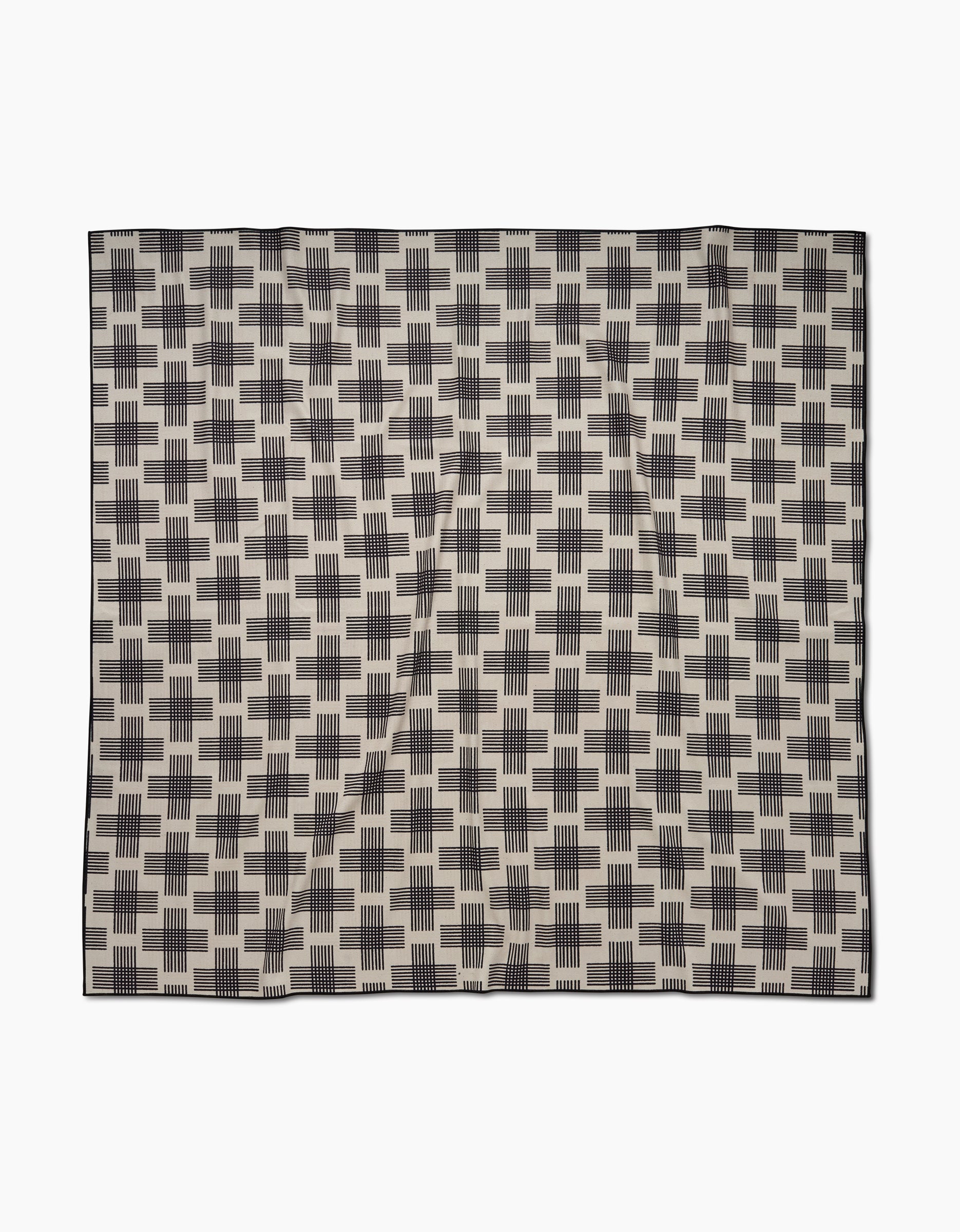 The Cross Hatch by Rosa Kichline is a square beach blanket crafted from quick-drying recycled materials, featuring a repeating black rectangular geometric pattern on beige with a thin black border.