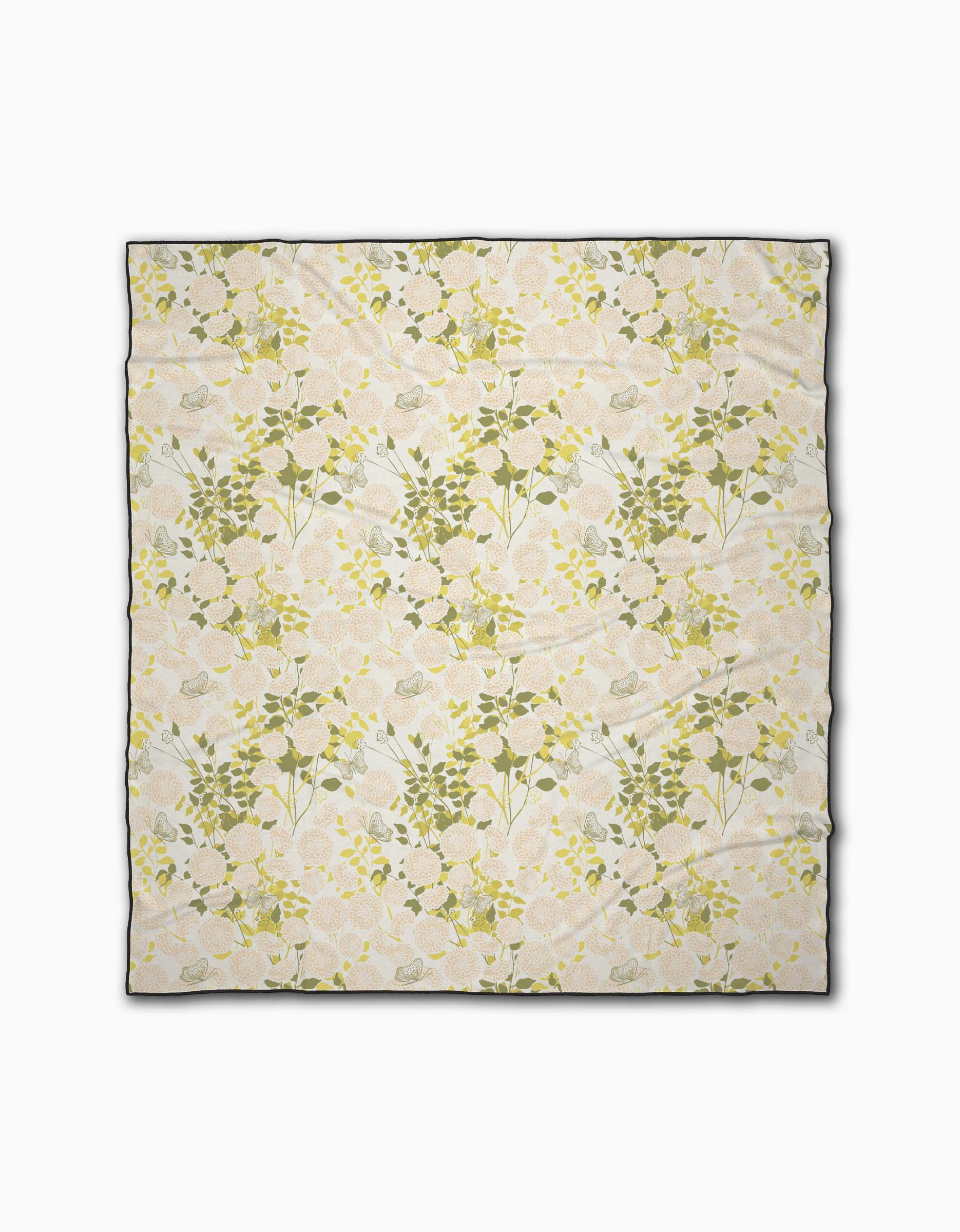The Lush Garden rectangular beach blanket by Second Nature Studio features a soft, pastel floral print on cream and is made from quick-drying recycled materials. Shown flat on a white background.