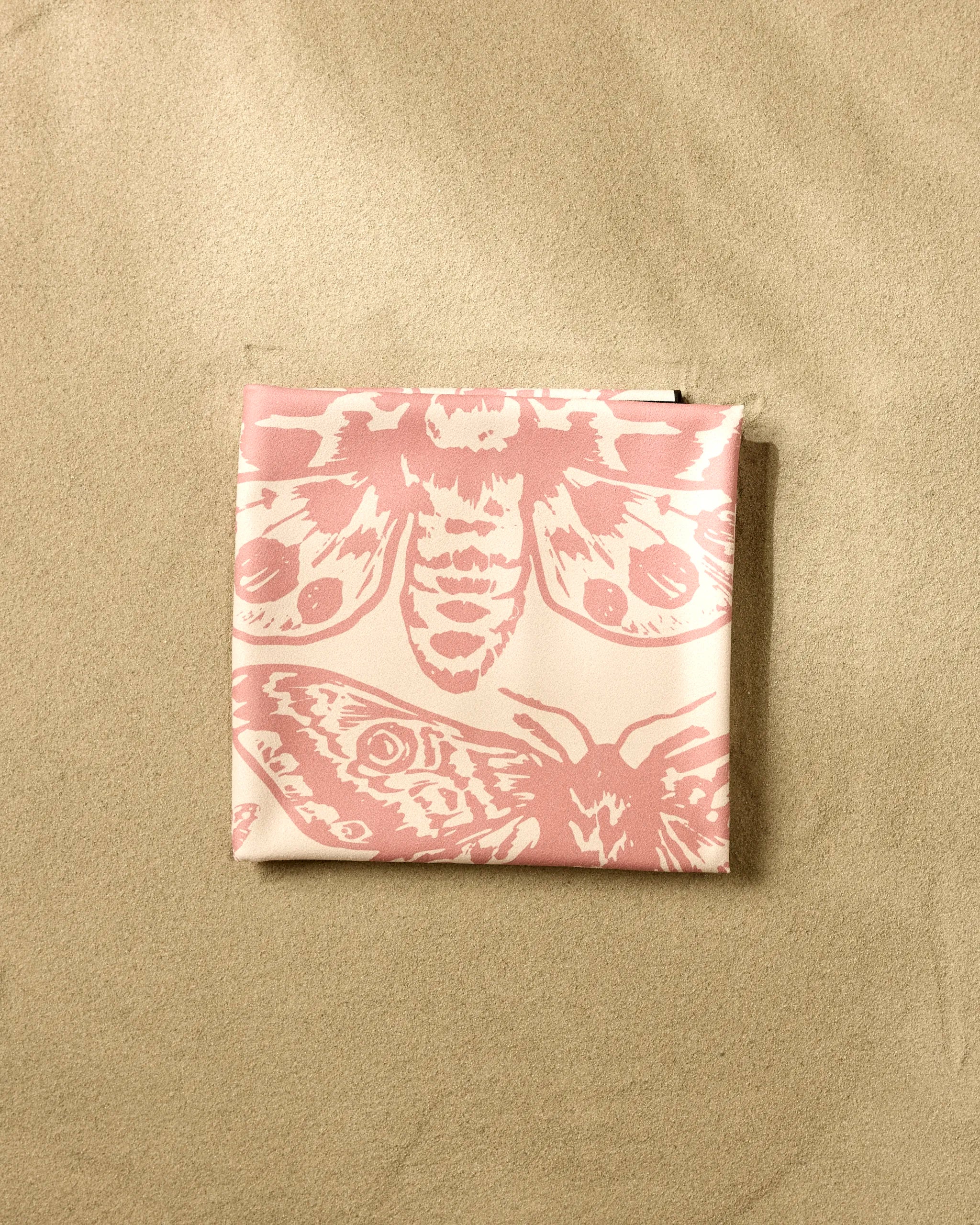 The GEOMETRY Mauvy Moths pouch features pink moths on a cream background—ideal for storing your Geometry Micro-loop Beach Blanket after a beach day.
