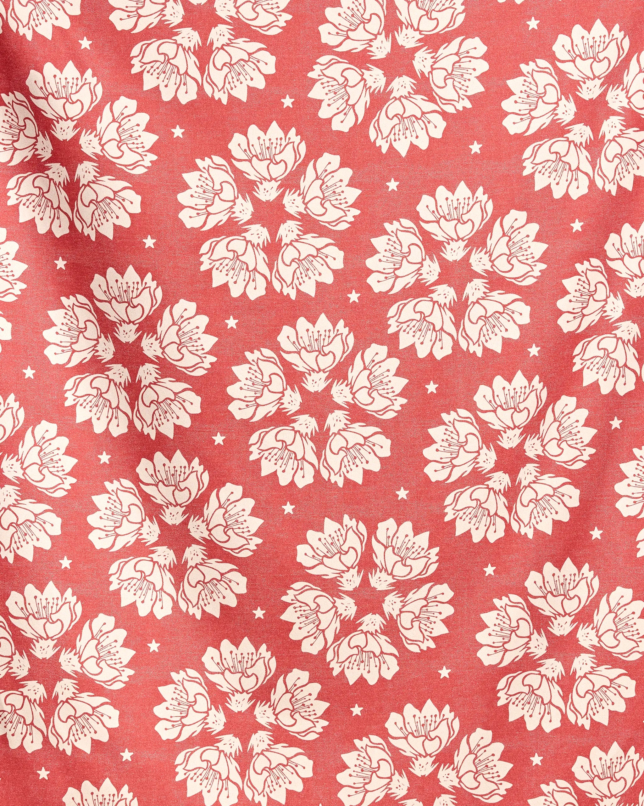 Maverick Floral by Geometry: a quick-drying beach blanket made from recycled materials, featuring red fabric with white floral clusters and scattered stars, plus subtle folds for texture.