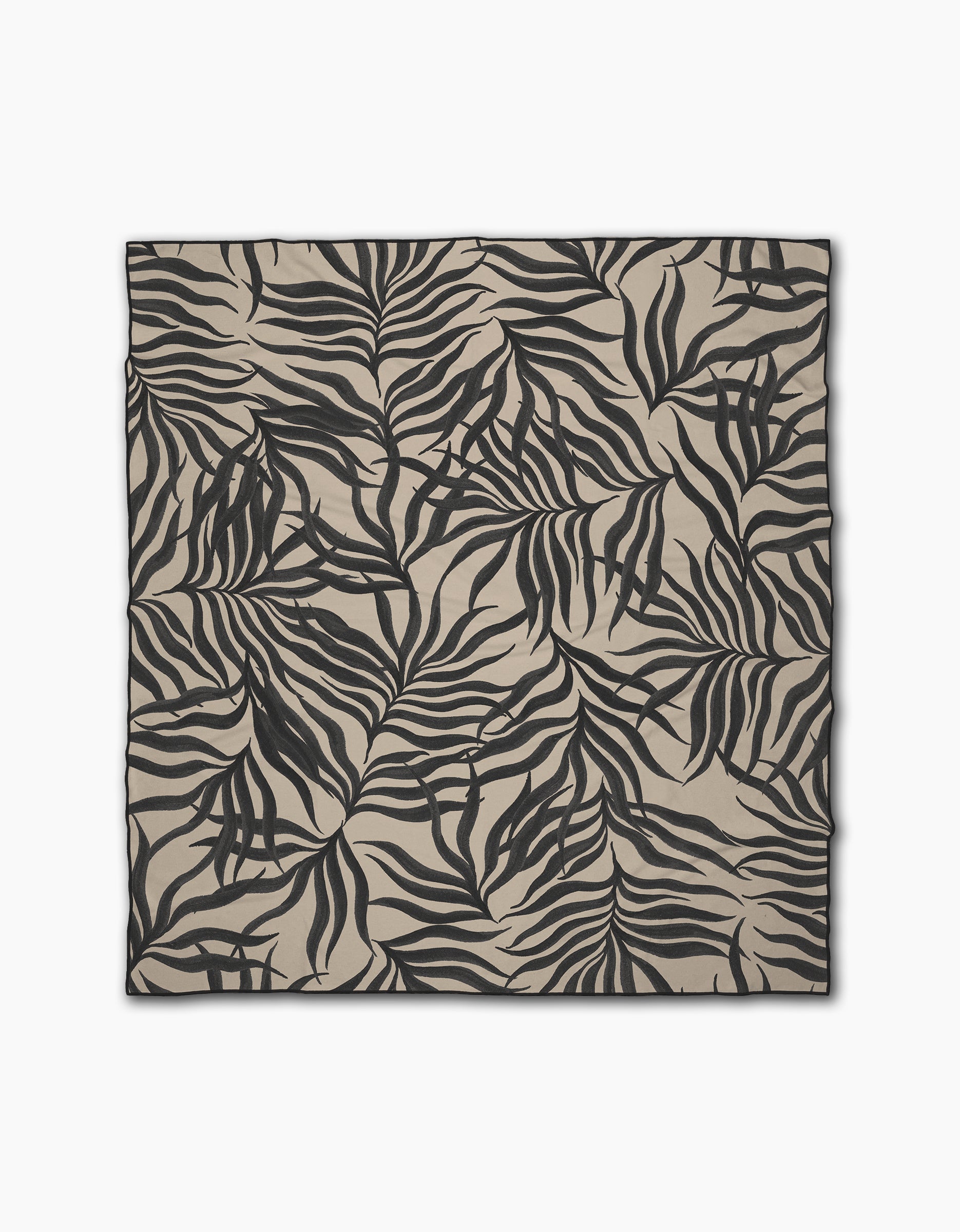 The Geometry Solar Flare is a square beige beach blanket featuring a bold black abstract leaf print and neatly finished edges. Made from quick-drying recycled materials, it offers tropical style, convenience, and sustainability.