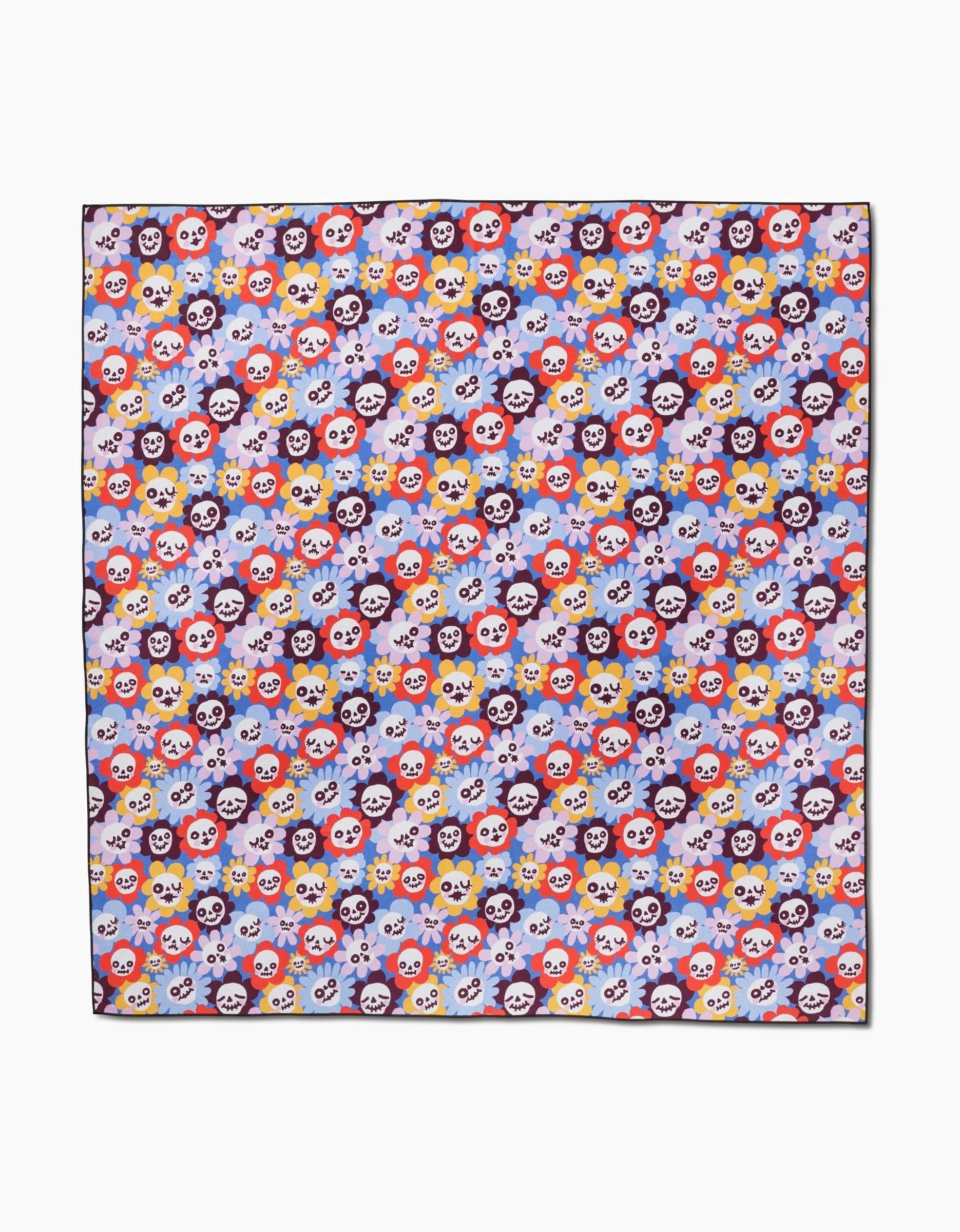 The So Lazo Spooky Bouquet is a square beach blanket with a colorful pattern of cartoon skulls—red, yellow, white, purple, and pink—on lavender. Made from quick-drying recycled materials, the skulls feature cute facial expressions.