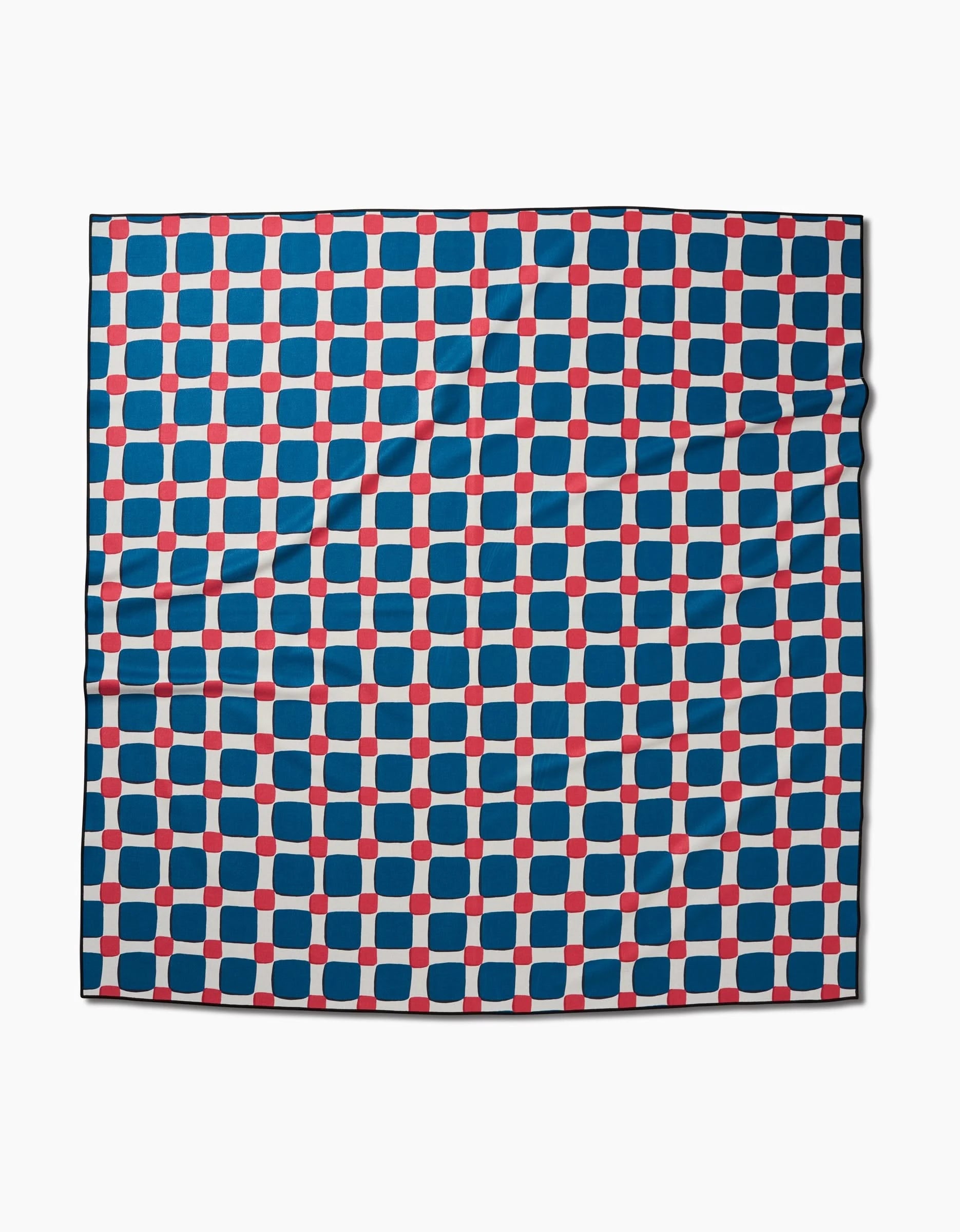 The Box Check Picnic scarf by Hufton Studio features a grid of blue squares and red dots on white. Made from quick-drying recycled fabric, it has a smooth, slightly wrinkled finish.
