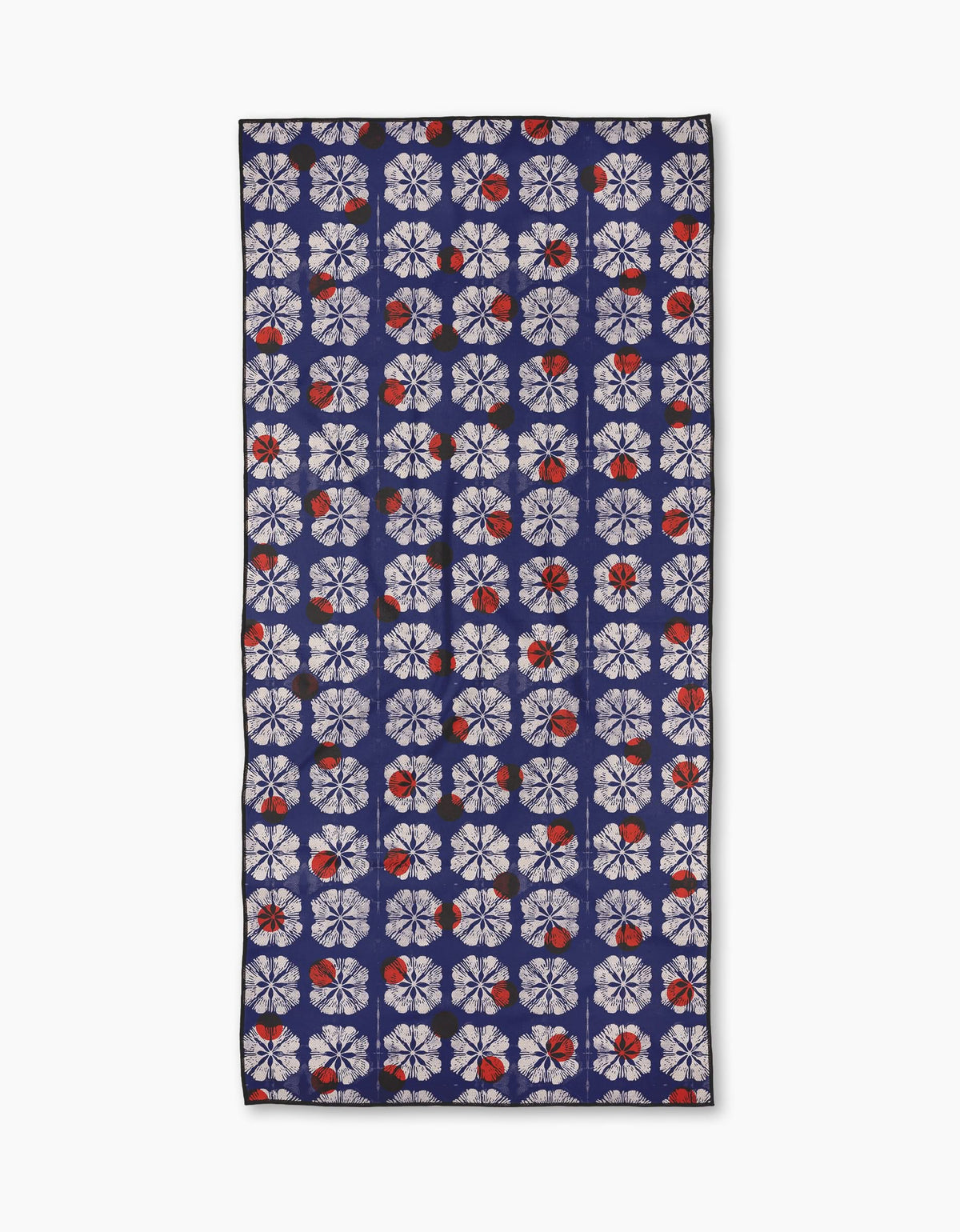 The Amanda beach towel by Geometry features a repeating pattern of white geometric floral shapes with red accents on a dark blue background, crafted from quick-drying recycled materials.