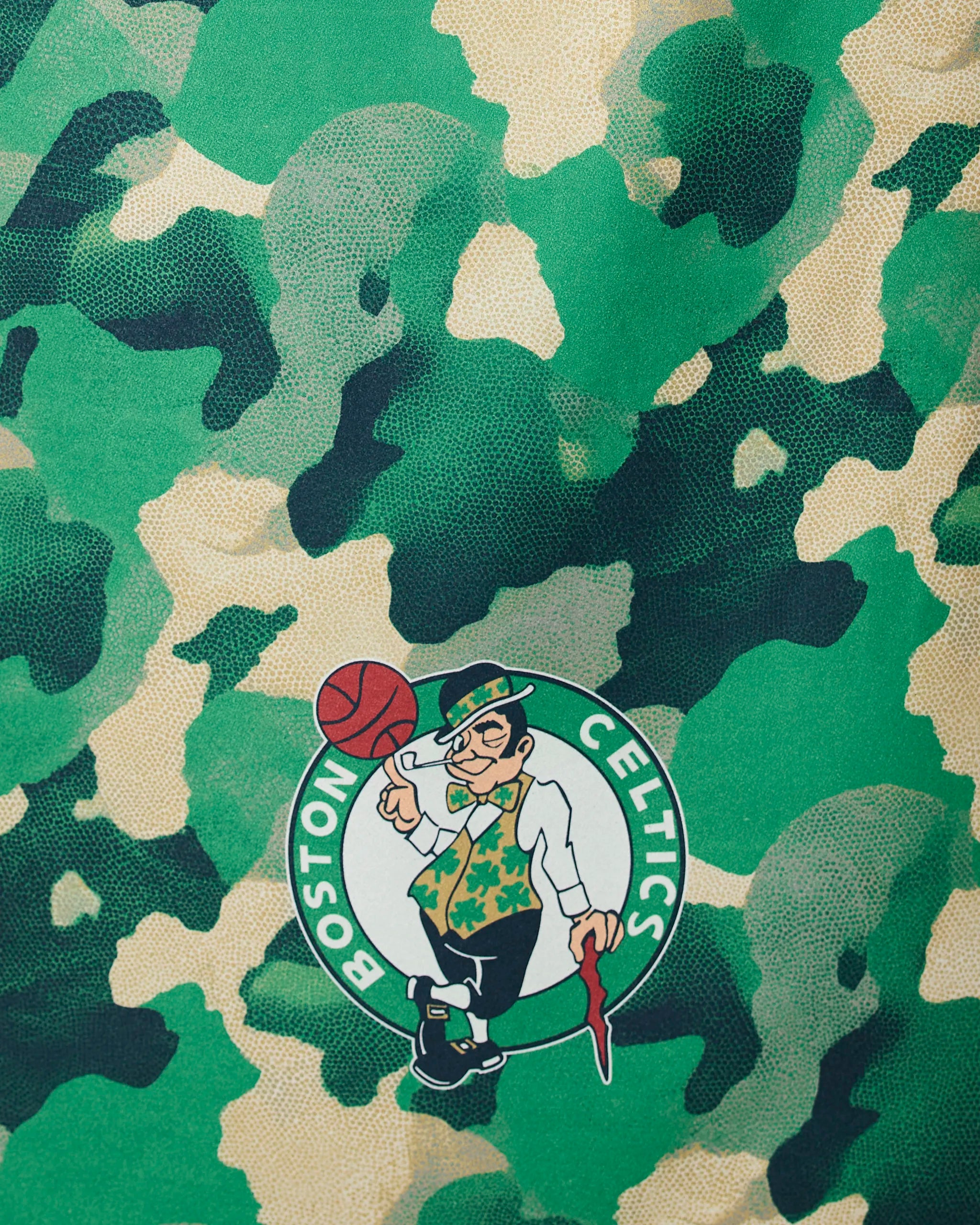 Geometry’s Celtics Camo features the Boston Celtics logo with a leprechaun spinning a basketball, set on a green and beige camouflage background.