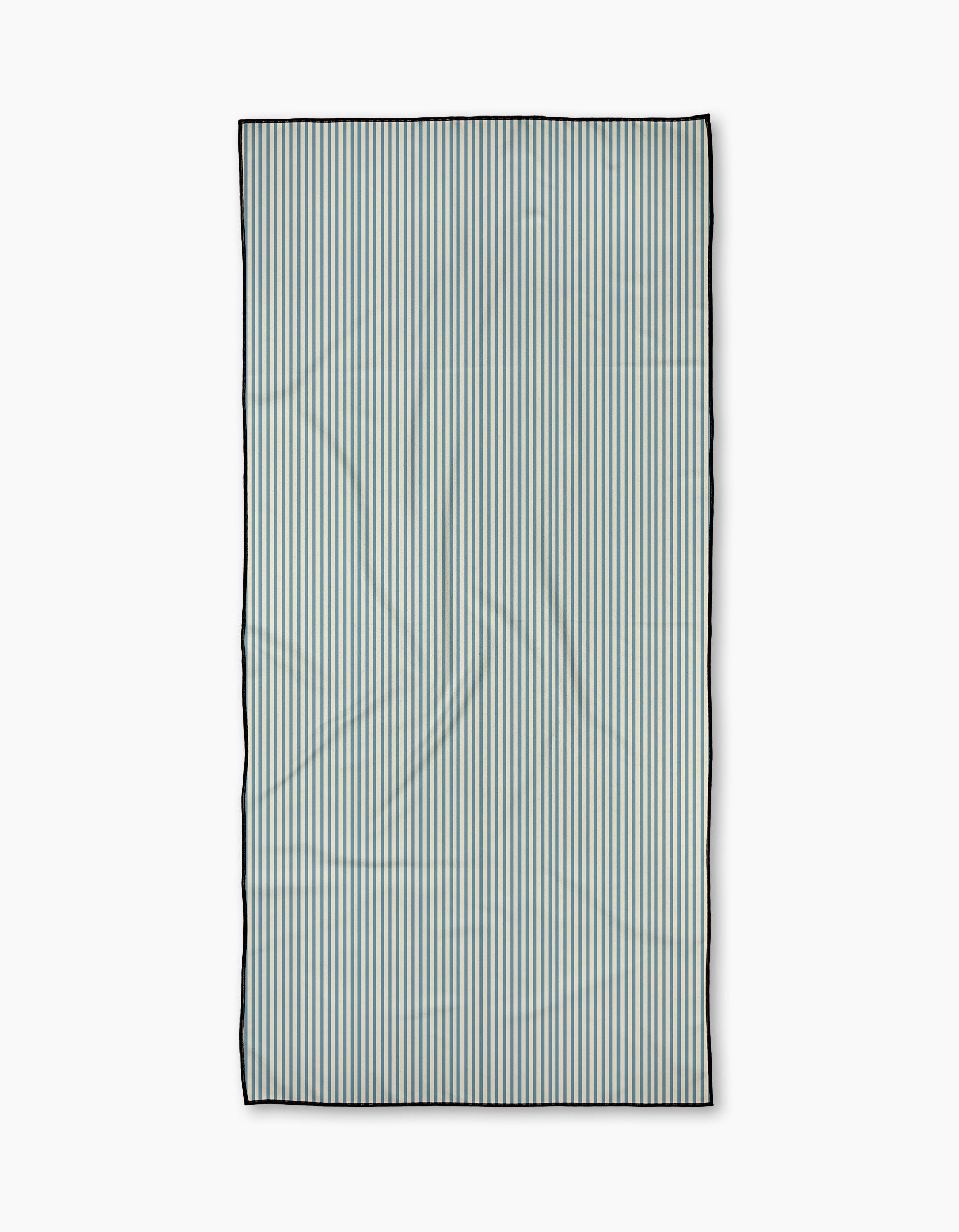 The Clean Slate beach towel by Susan Heid is rectangular and quick-drying, featuring thin, evenly spaced vertical blue and white stripes with a dark border, shown on a plain white background.