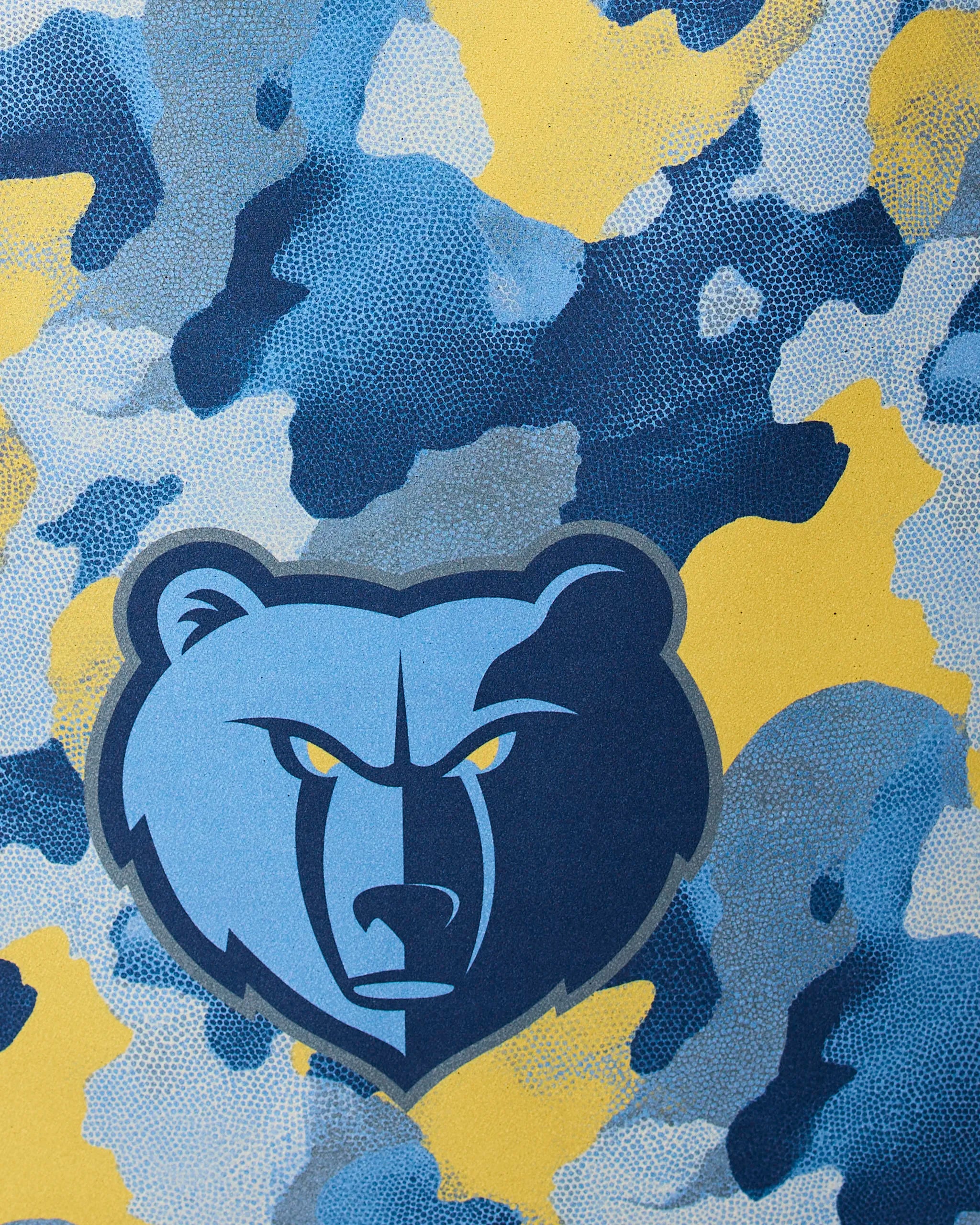 The Geometry Grizzlies Camo features a stylized blue and gray bear head logo with yellow eyes, centered on a blue, yellow, gray, and white camouflage background.