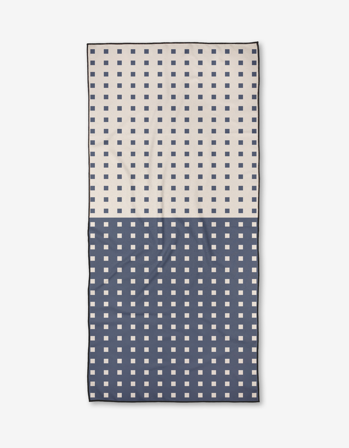 The Harmony Haze by Happy Hemera is a rectangular Micro-loop Beach Towel featuring cream and navy halves with contrasting square grids, crafted from quick-drying recycled materials for sustainable style.