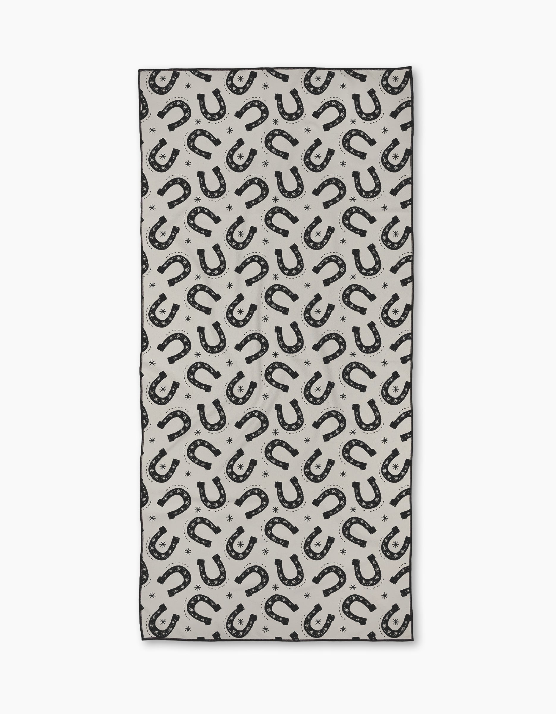 The Geometry Lucky Stride Micro-loop Beach Towel features a repeating black horseshoe and small star pattern on light gray. Made from recycled materials, this quick-drying rectangular towel shows horseshoes in various directions.