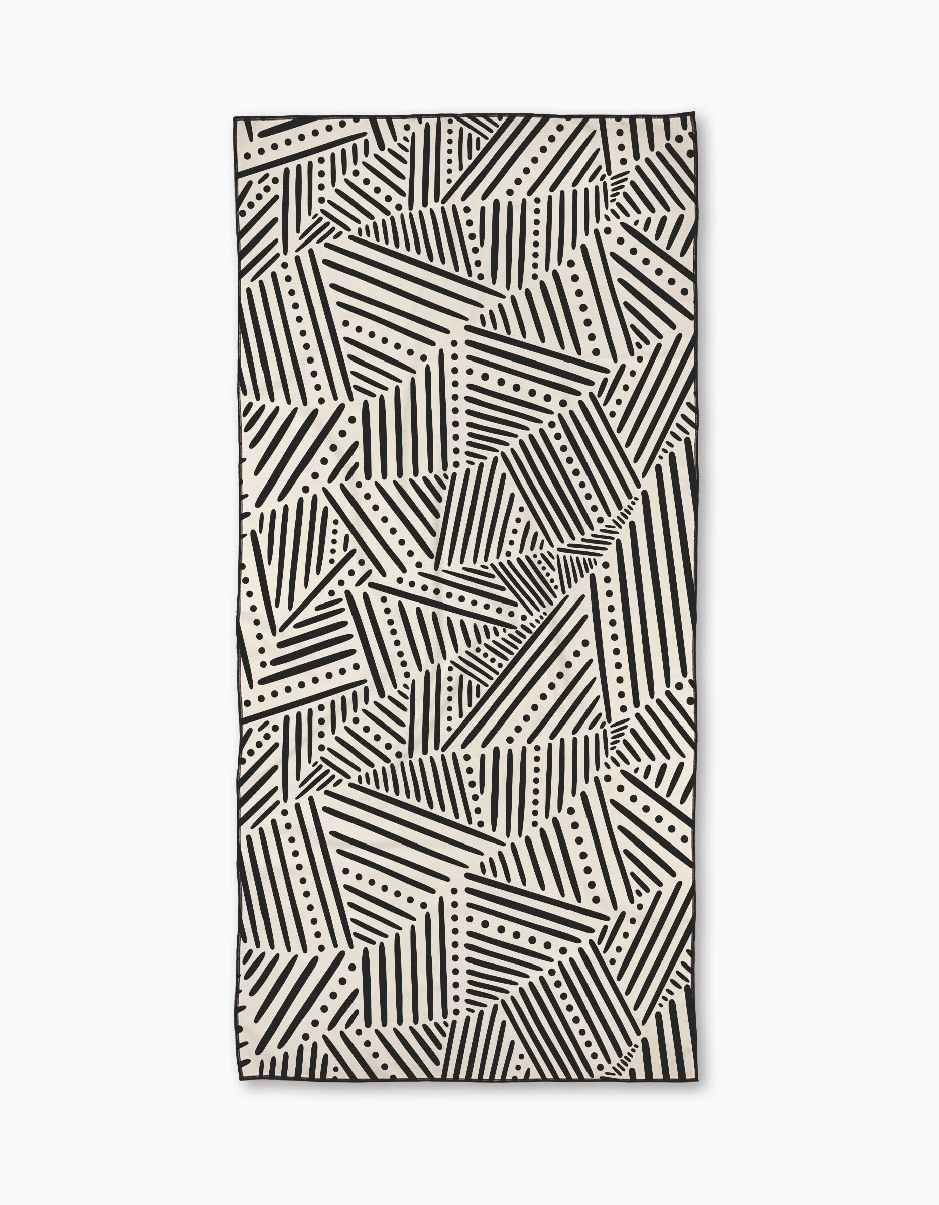 The Rhythm Current Stripes towel by Sarah Daugherty is a rectangular beach towel with a black and white geometric pattern of diagonal lines and dots, creating an abstract, repeating design.