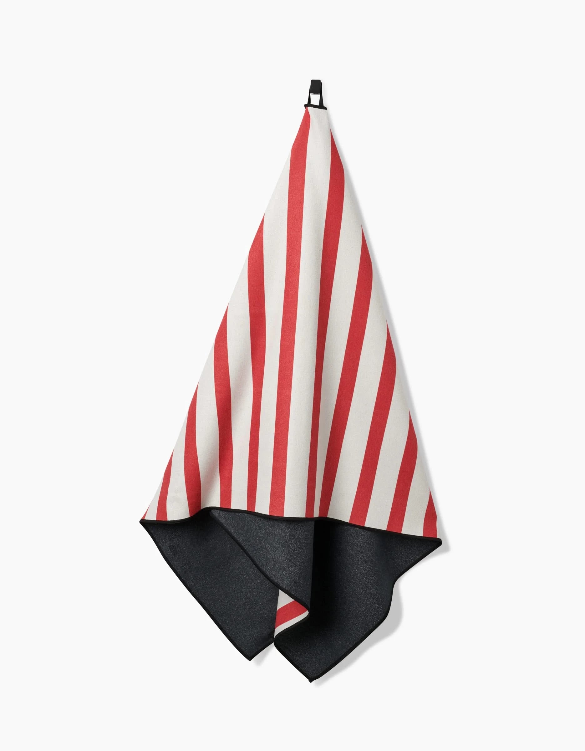 The Mindfulnice USA Stripes Micro-loop Beach Towel features diagonal red and white stripes on one side and solid black on the reverse, made from quick-drying recycled materials. Shown hanging from a black hook against a white background.