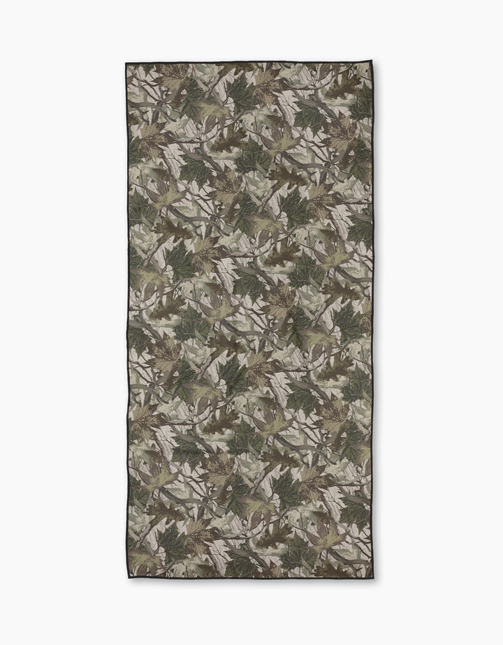 The Geometry Dad Camo Micro-loop Beach Towel features a green, brown, and beige woodland camo print, made from recycled materials and shown flat on a white background.