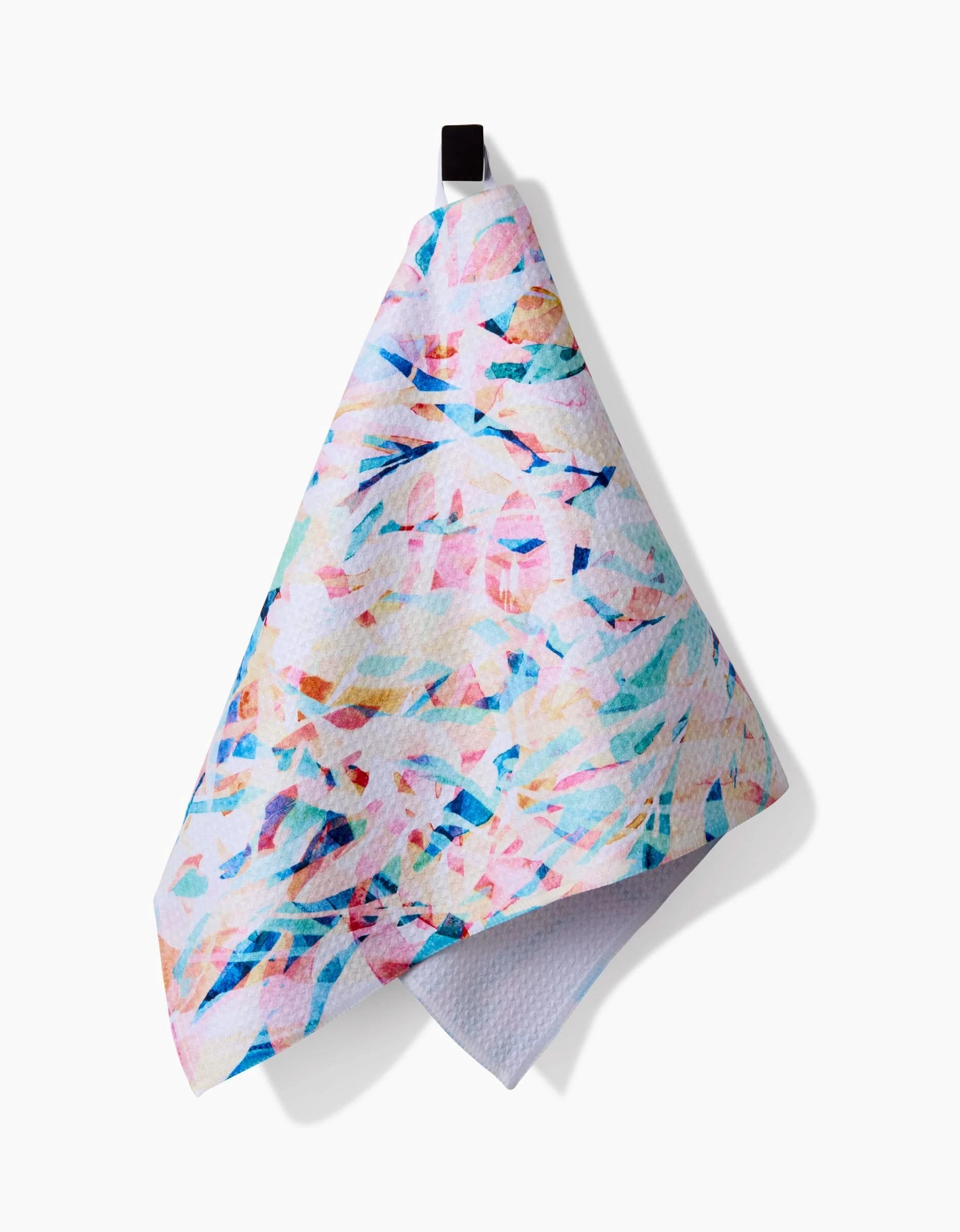 The Rachel Parker Abstract Jungle bar towel features pastel pink, blue, and teal abstract patterns on Geoweave fabric made from recycled materials, hanging by a black loop against a white background.