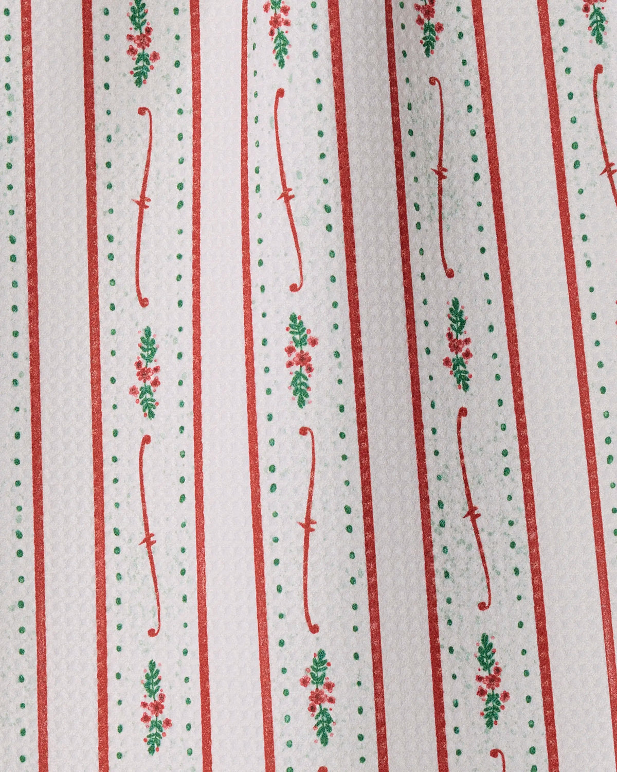 Vertical stripes of red, white, and green adorned with delicate floral and dot motifs repeat across a textured surface—invoking vintage festive décor. The Alpine Trim design by Geometry is printed on soft Geoweave fabric, making it an ideal choice for a recycled kitchen or mini towel that brings both style and sustainability to your home.