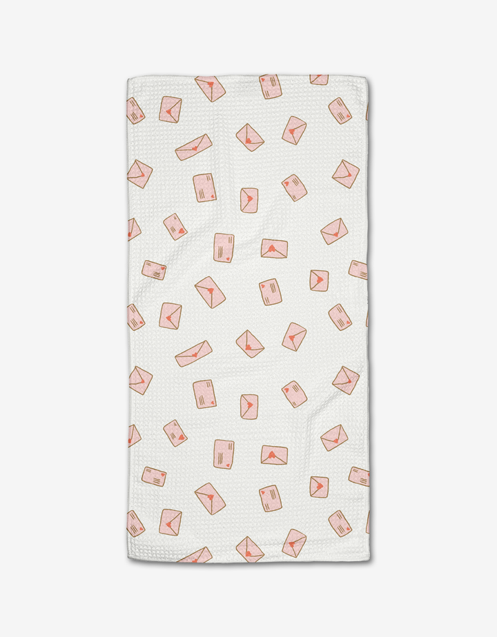 The Amatus Bar Towel by Amy MacCready features white textured Geoweave fabric with a scattered pink envelope and mail parcel pattern. Ultra-absorbent and stylish, its perfect for everyday use. Displayed on a plain white background.