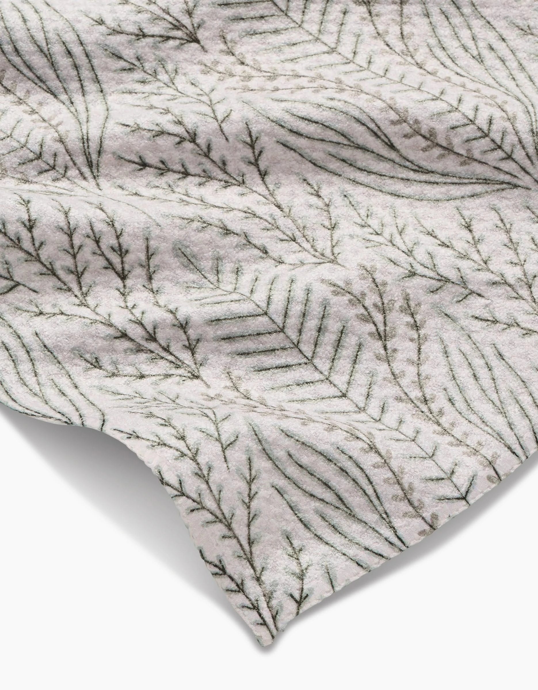 A close-up of the Amy MacCready Amberlin Bar Towel shows its soft, ultra-absorbent fabric and a delicate pattern of overlapping leaves and branches in muted green tones, with smooth texture, gentle folds, and subtle shadows.