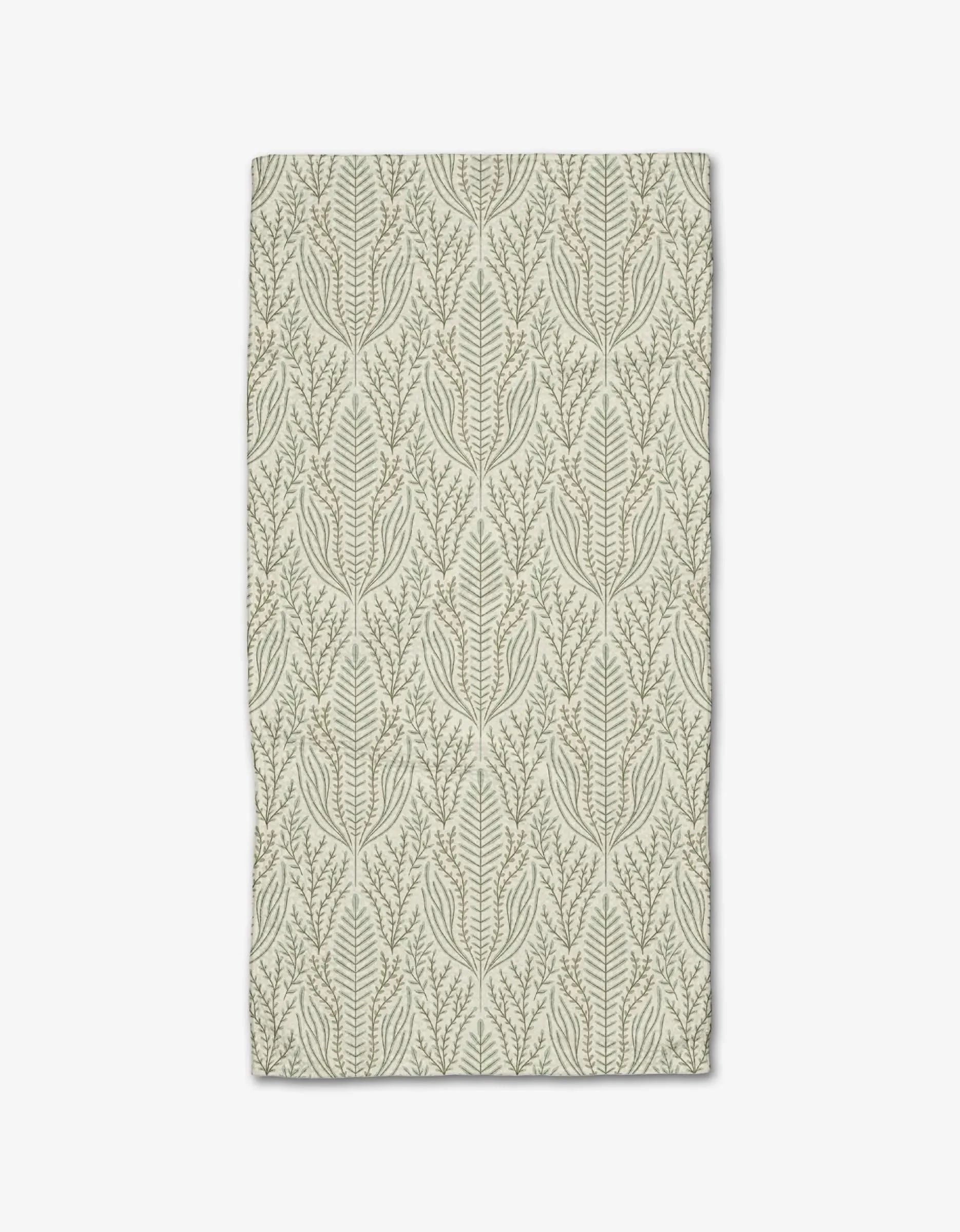 The Amberlin towel by Amy MacCready is a rectangular beige bar towel crafted from recycled materials, featuring symmetrical green leafy branches and vines that stand out against the light background.
